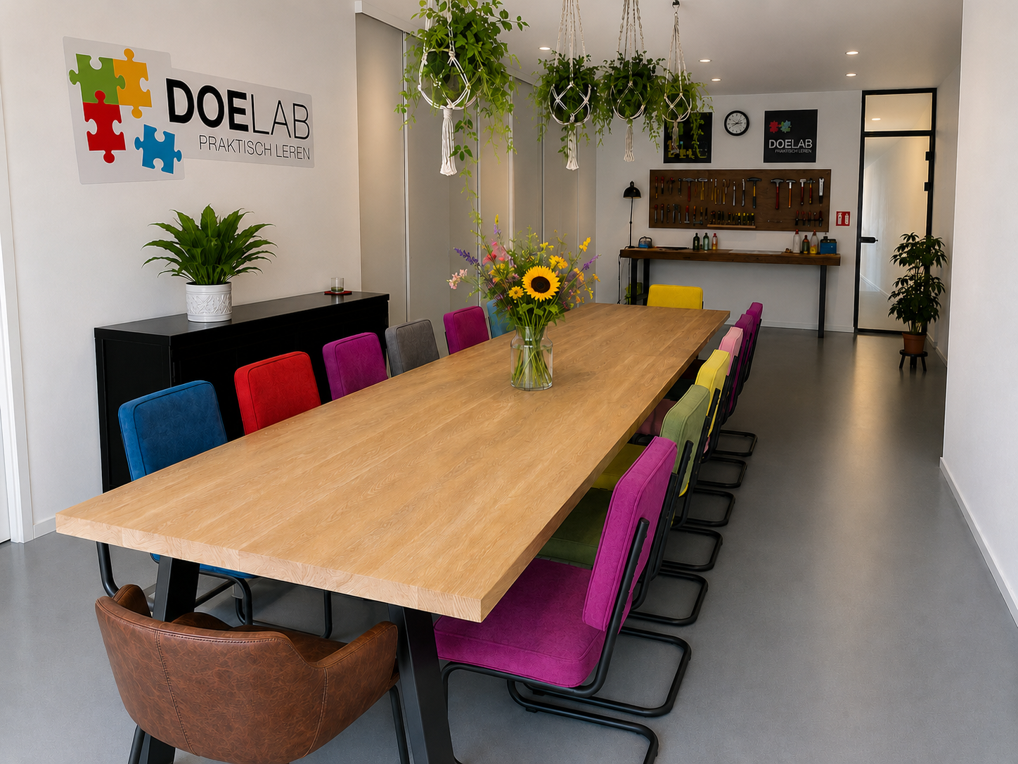 Trainingsruimte huren in Amsterdam met grote tafel, gekleurde stoelen en creatieve werkbank